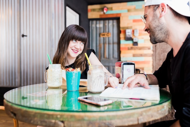 Young woman pointing over books at the cafe table