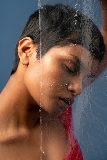 Young woman portrait behind plastic wrap