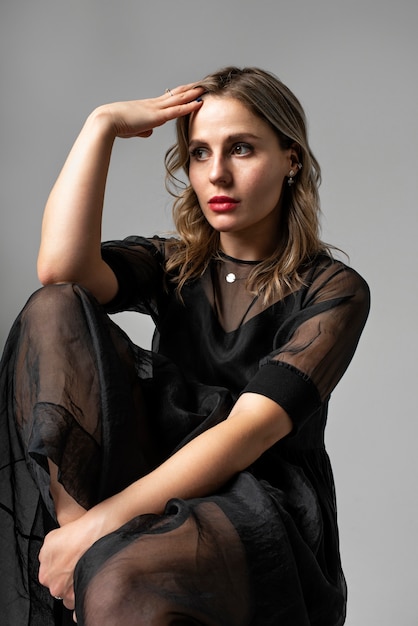 Free photo young woman posing in black dress medium shot