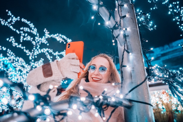 Young woman posing at the street with illuminated trees