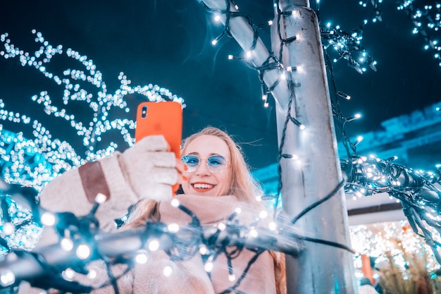 Free Photo young woman posing at the street with illuminated trees