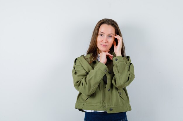 Young woman posing while thinking in shirt, jacket and looking graceful , front view.