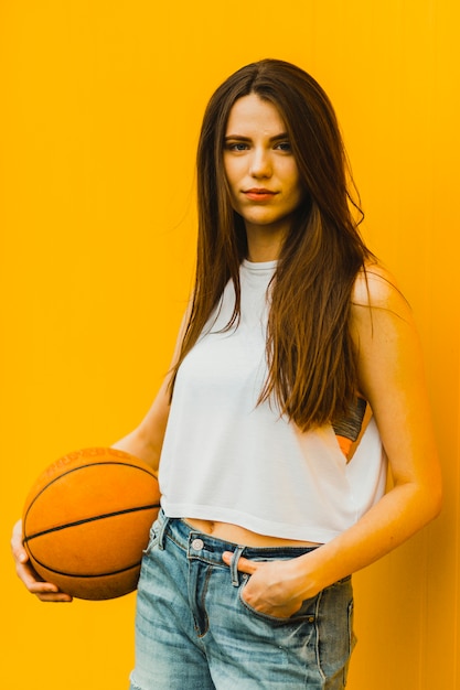 Free photo young woman posing with basketball