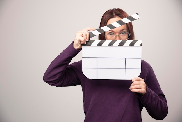 Young woman posing with a cinema tape on a white . High quality photo