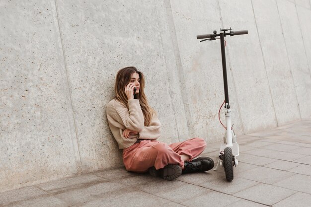 Young woman posing with an electric scooter