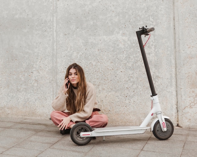 Young woman posing with an electric scooter