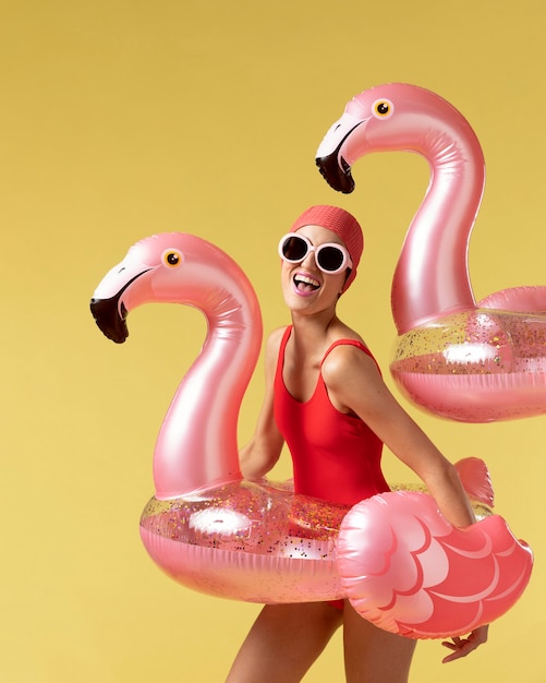 Free Photo young woman posing with flamingo swimming ring