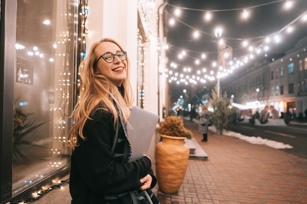 Young woman posing with a laptop on the street