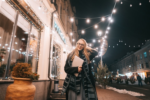 Young woman posing with a laptop on the street