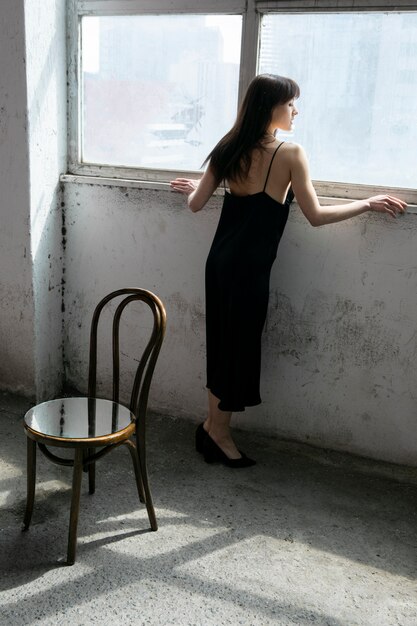 Young woman posing with mirror and chair