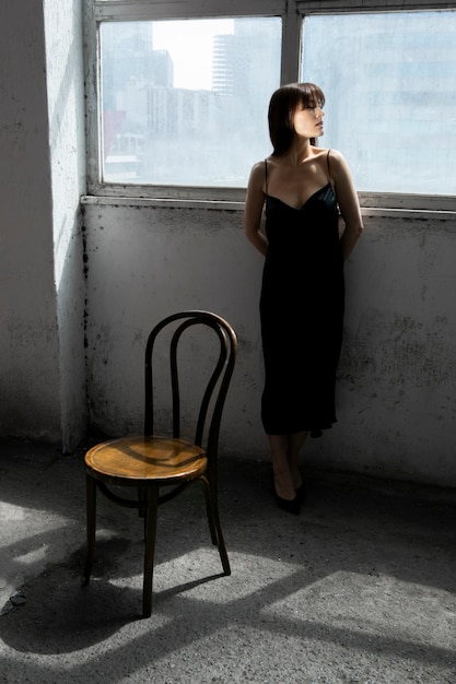 Young woman posing with mirror and chair