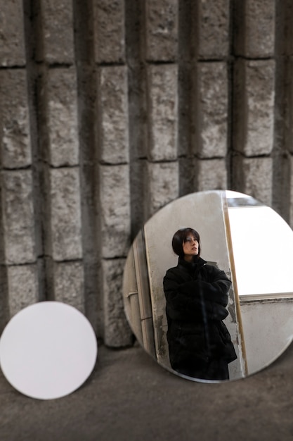 Free Photo young woman posing with mirror creating beautiful reflections