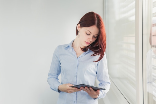 Free photo young woman posing with tablet