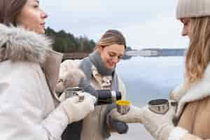 Free photo young woman pouring her friends water in cups