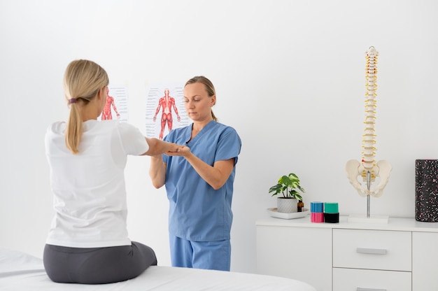 Free photo young woman practicing an exercise in a physiotherapy session