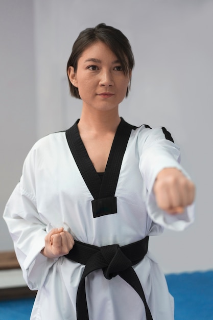 Free photo young woman practicing taekwondo in a gymnasium