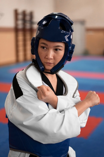 Free photo young woman practicing taekwondo in a gymnasium