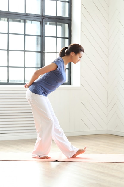 Young woman practicing yoga on a yoga mat