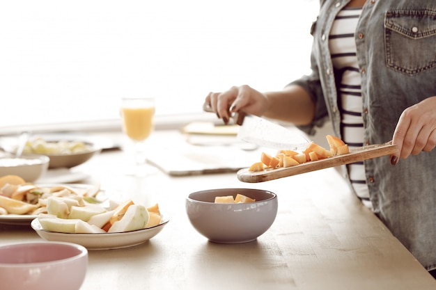 Free photo young woman prepares breakfast in the kitchen