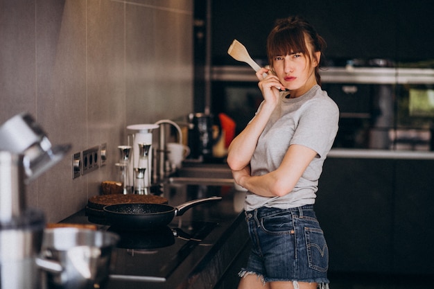 Free photo young woman preparing breakfast in kitchen in the morning