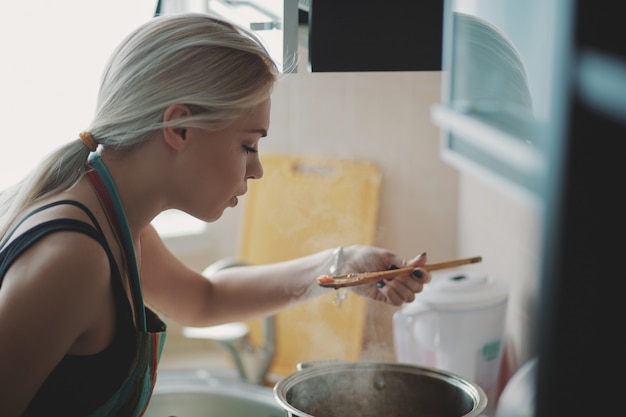 Free Photo young woman preparing pumpkin soup