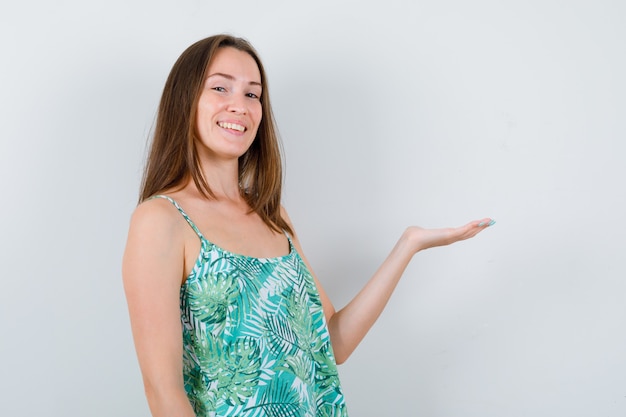 Young woman pretending to hold something and looking cheery. front view.