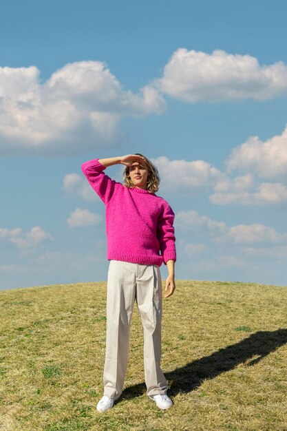 Young woman protecting her eyes from the sun in an outdoor field