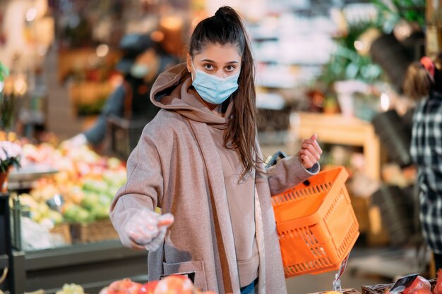 Young woman in protective mask makes purchases in the supermarket