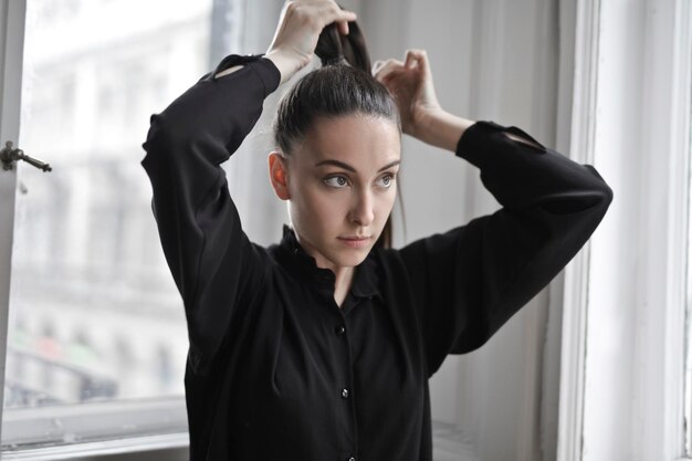 Young woman puts her hair back