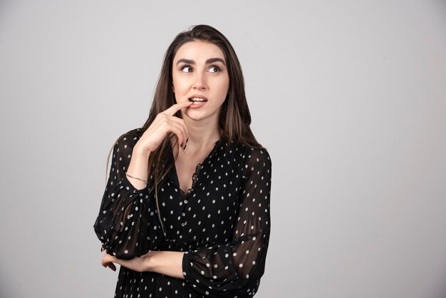 Young woman putting her finger to her mouth.