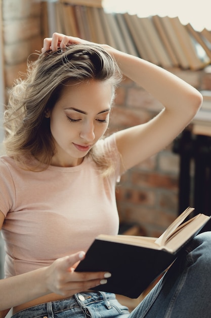 Free photo young woman reading a book at home