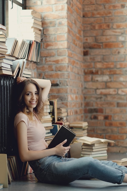 Free photo young woman reading a book at home