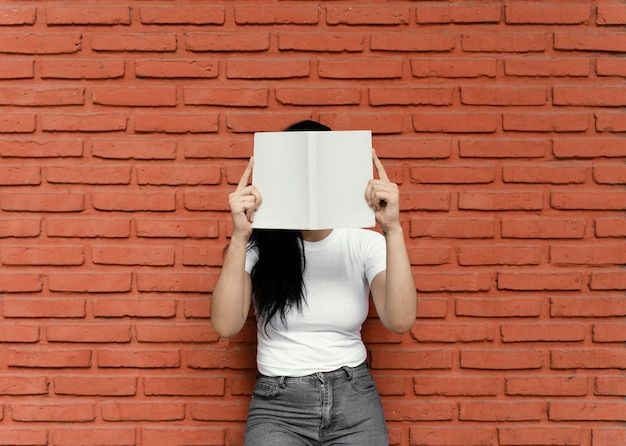 Free Photo young woman reading an interesting book outdoors