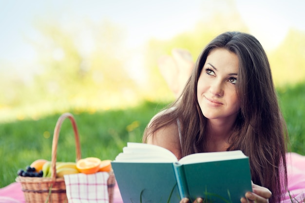 Young woman reading on meadow