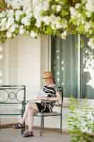 Free photo young woman reading outdoors