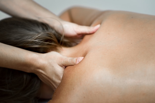 Young woman receiving a back massage in a spa center.