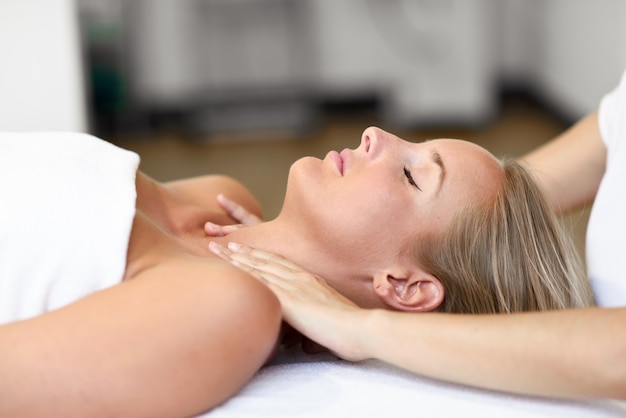 Young woman receiving a head massage in a spa center.