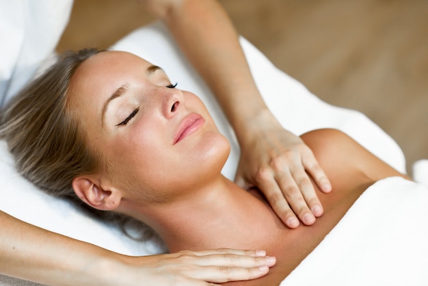 Young woman receiving a head massage in a spa center.