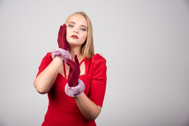 Young woman in red dress posing to camera. 