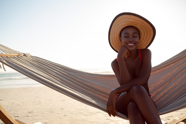 Young woman relaxing in a hammock on the beach