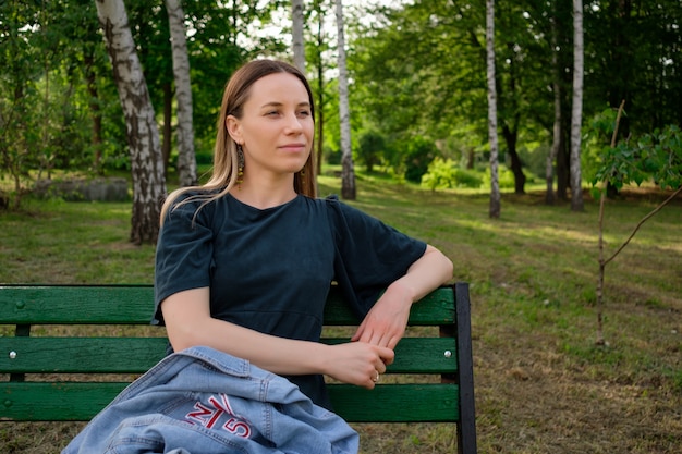 Young woman relaxing in the park sitting on a chair