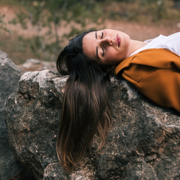 Young woman relaxing on rock