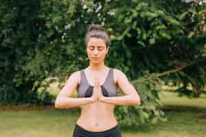 Free photo young woman relaxing while meditating and joining hands in mudra