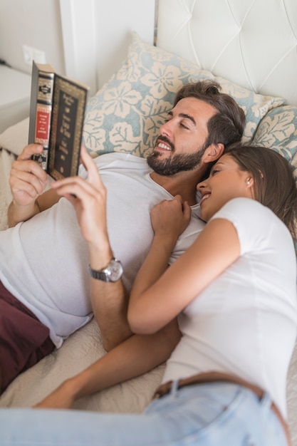 Young woman resting near reading man