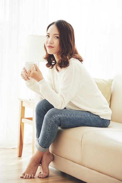 Young woman resting with a cup of tea