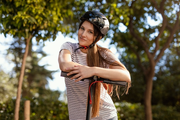 Young woman rides in a electrical scooter in a park