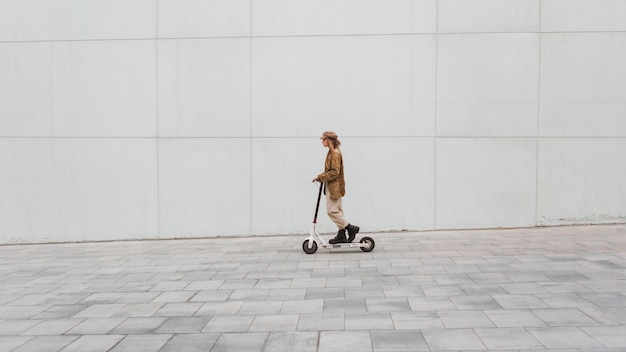 Free Photo young woman riding an electric scooter