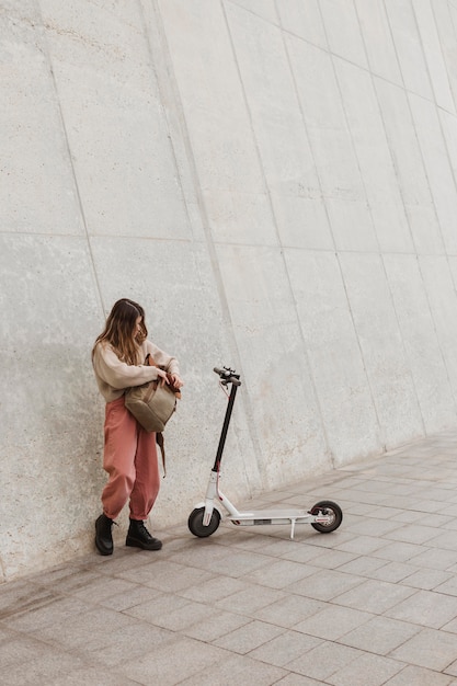 Free photo young woman riding an electric scooter