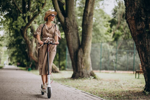 Young woman riding scooter in park