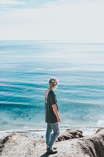 Young woman on a rock near the shore